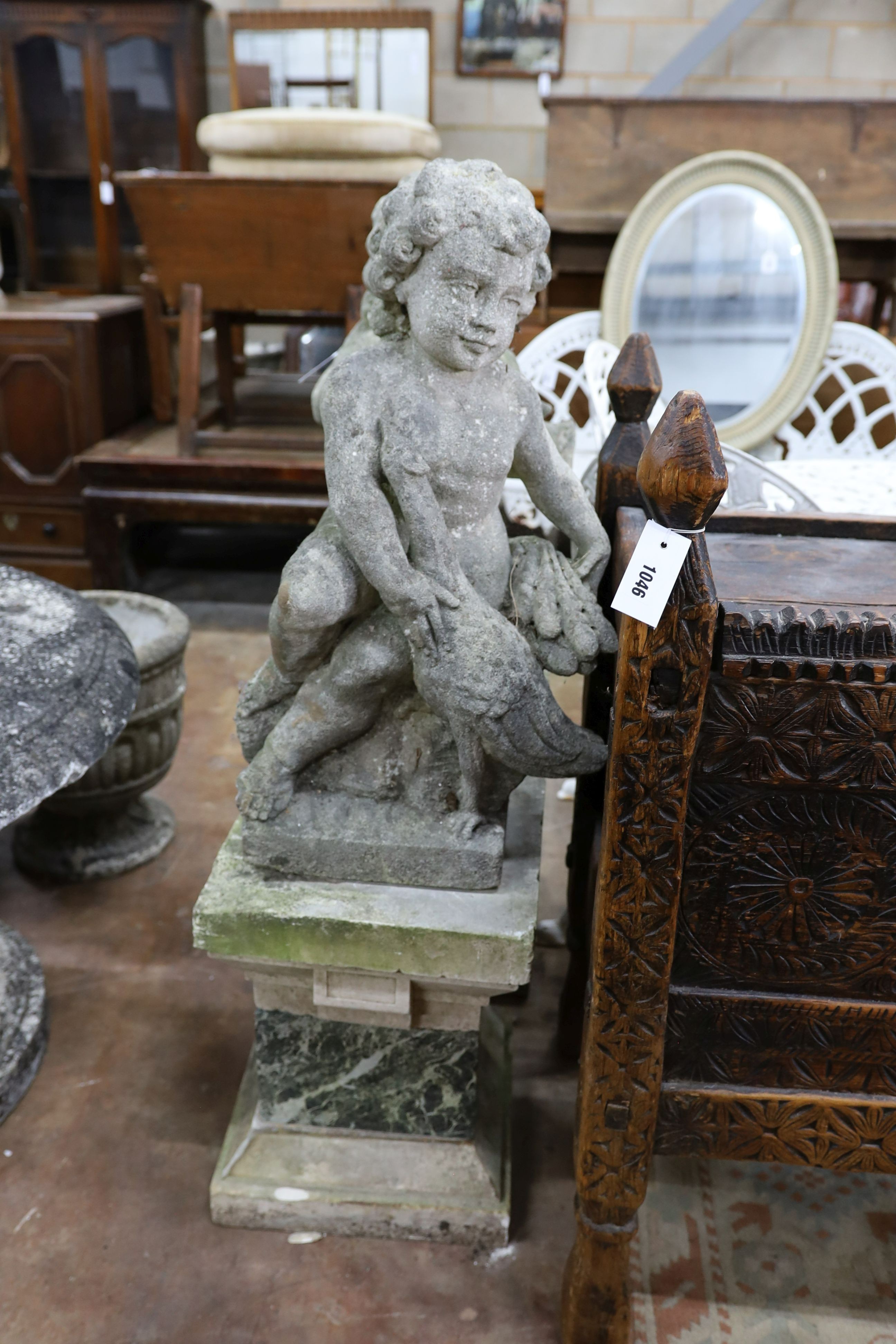 A pair of reconstituted stone cherub and dove garden ornaments on faux marble plinths, height 116cm